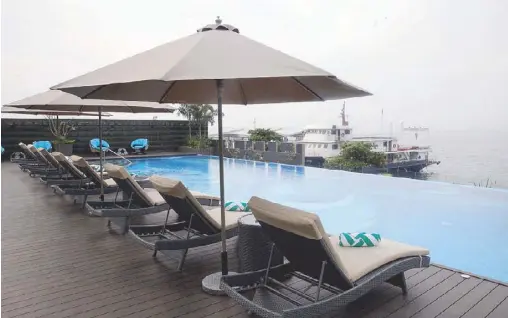  ??  ?? In the swim: The Olympic-size infinity pool overlooks the marina and Manila Bay sunset.