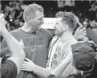  ?? MATT YORK AP ?? Mavericks guard Luka Doncic (right)embraces former Dallas star Dirk Nowitzki after Game 7 win Sunday over the Suns.