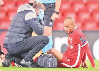  ?? — AFP photo ?? Fabinho receives medical attention after picking up an injury during the UEFA Champions league Group D match between Liverpool and Midtjyllan­d at Anfield in Liverpool.