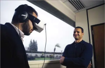  ?? BRIAN L FRANK/THE NEW YORK TIMES ?? David Dicko (right) CEO of the startup SkyLights, shows his VR headset in Sunnyvale, California.