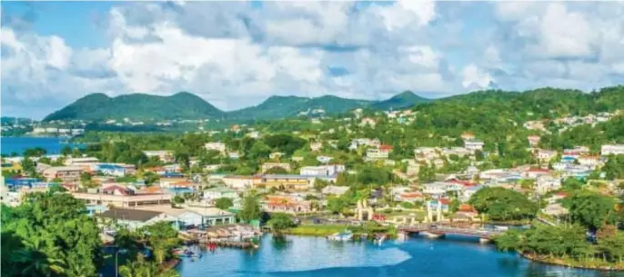  ?? GETTY IMAGES ABOVE, TNS RIGHT ?? CALMING VIEW: Lush hills surround Castries, above, the capital and cruise port of St Lucia. Catamarans in a row at Carlisle Bay in Antigua, right, await beach-goers