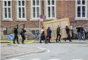  ?? Via Reuters /Ritzau Scanpix/Ida Marie Odgaard ?? Heritage rescue: Volunteers carry historic paintings out of the Old Stock Exchange, Boersen, during a fire in the historic building, in Copenhagen, Denmark, on Tuesday.