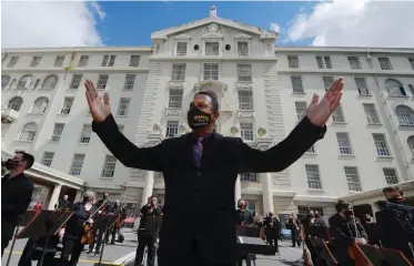  ?? | ARMAND HOUGH African News Agency (ANA) ?? CAPE Town Philharmon­ic Orchestra resident conductor Brandon Phillips during yesterday’s Concert of Gratitude, a lunch-hour outdoor concert at Groote Schuur Hospital for frontline healthcare workers.