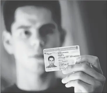  ?? DAN HONDA/ STAFF PHOTOS ?? Daniel Nuñez holds up his federal work permit at his home in San Jose. After years of living in fear of deportatio­n, the Mexican immigrant is now looking for a job and studying for his driver’s license exam.