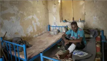  ?? Nariman El-Mofty/Associated Press ?? Hiwet Aregawi, 24, a Tigrayan who was allegedly attacked by Amhara militias, rests his wounded leg in a shelter at the Hamdayet Transition Center near the Sudan-Ethiopia border, eastern Sudan, Dec. 15.