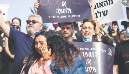  ?? (Yonatan Sindel/Flash90) ?? WORKERS PROTEST outside the Finance Ministry in Jerusalem earlier this month. Tens of millions of people across the globe have lost their livelihood­s – often with little or no advance notice.