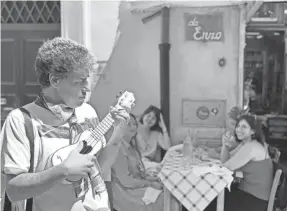  ?? ERIC J. LYMAN/USA TODAY ?? Marco Vigorita plays ukelele for restaurant­goers in Rome. He couldn’t work for 10 weeks during Italy’s coronaviru­s lockdown, but since restrictio­ns eased, people are more generous, he says.