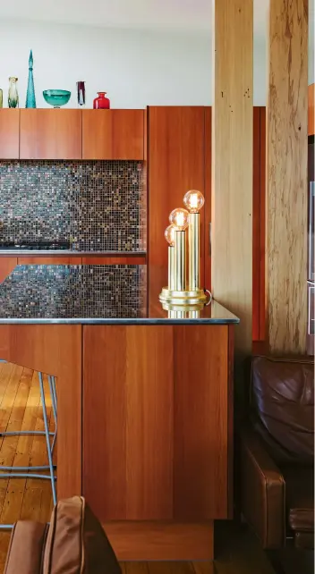  ??  ?? THESE PAGES (from left) Ceiling beams were repurposed as a divider to give some separation to the kitchen which Matt designed with the input of Paige Adams from Elite Kitchens. The kitchen features a cantilever­ed island, slimline stainless steel benchtops and glass mosaics with a tortoisesh­ell effect on the splashback wall. Matt found the coloured glassware and trio lamp at Mid Century Found while the much-used Atomic coffee pot was a Trade Me find.