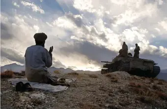  ??  ?? An Afghan soldier praying near Tora Bora during fighting against the Taliban, December 2001