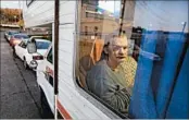  ?? TED S. WARREN/AP ?? Stanley Timmings looks out of the window of the RV where he lives with his girlfriend in Seattle. The couple lost the room they were renting in a house when the owner died.