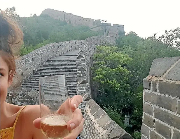  ??  ?? Nicky Park enjoys a glass of Champagne on the Great Wall of China at sundown.