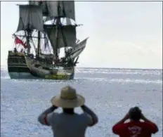  ?? RONEN ZILBERMAN - THE ASSOCIATED PRESS ?? In this 1999 photo, people watch as a replica of the HMB Endeavour leaves Honolulu, as it embarked on a four-year, around-the-world cruise. The original vessel was commanded by Capt. James Cook in the 1700s when he became the first European to chart Australia’s East Coast. Researcher­s said in September 2018 they’ve found a site where they think the ship that Cook used sank and may be located, and are planning an excavation off the coast of Rhode Island.