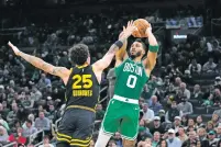  ?? STEVEN SENNE/THE ASSOCIATED PRESS ?? Celtics forward Jayson Tatum shoots over Warriors guard Lester Quinones during Sunday’s game in Boston. Brown scored 27 points on his birthday as the Celtics won by 52 points.