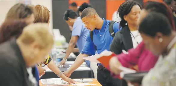  ?? GETTY IMAGES ?? Job seekers check out opportunit­ies at a job fair in Chicago. “Denying people rights that they don’t already enjoy is one thing; denying people rights that they’ve learned to take for granted is another,” one critic says of changes to labour laws that...