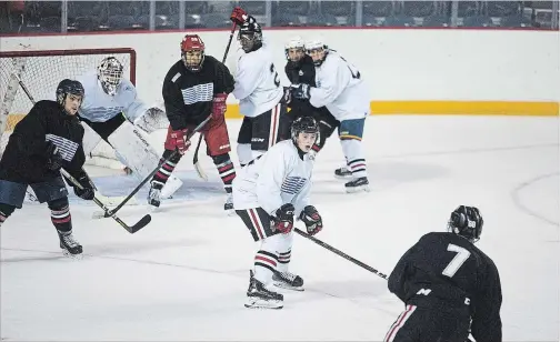  ?? BOB TYMCZYSZYN THE ST. CATHARINES STANDARD ?? Lleyton Moore, centre, takes away a passing lane in the IceDogs’ Black and White game Thursday at Meridian Centre.