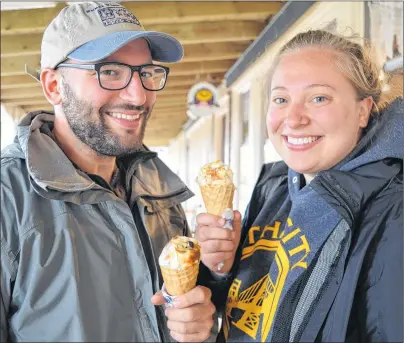  ?? MAUREEN COULTER/THE GUARDIAN ?? Brian Azimou and Camille Traill of Montreal, Que. eat some COWS ice cream as they browsed the shops along the Cavendish Boardwalk. The couple was here to take in the Anne of Green Gables house in addition to eating plenty of lobster and oysters.