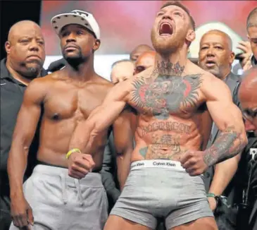  ?? AFP ?? UFC lightweigh­t champ Conor McGregor (right) screams after the weighin as Floyd Mayweather Jr looks on in Las Vegas on Saturday.