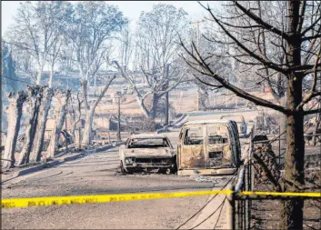  ?? Noah Berger The Associated Press ?? Vehicles and and homes destroyed by the Mill Fire line a neighborho­od in Weed, Calif., on Saturday. The blaze has destroyed more than 100 homes and buildings.