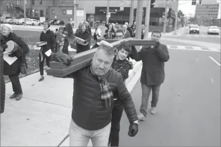  ?? DAVID BEBEE PHOTOS, RECORD STAFF ?? Members of Trinity United Church, front to back, Peter Oliver, Garrett Brathwaite, Tim Oliver, and Ben Oliver, rear right, carry a cross down Frederick Street toward the congregati­on’s new home at St. Matthews Lutheran Church in Kitchener, Sunday.