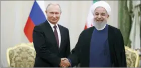  ?? EBRAHIM NOROOZI — THE ASSOCIATED PRESS ?? Iran’s President Hassan Rouhani, right, shakes hands with Russia’s President Vladimir Putin, in Tehran, Iran, Friday, after their talks, part of Russia-Iran-Turkey summit to discuss Syria, Friday.