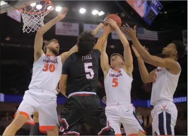  ?? Washington Post photo ?? Virginia’s Kyle Guy (5) grabs a rebound in a crowd of Jay Huff, left, De’Andre Hunter, right, and Gardner Webb’s Jose Perez. The No. 1 Cavaliers overcame a 14-point first-half deficit to pull away from the No. 16 Runnin’ Bulldogs.