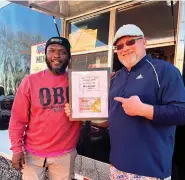  ?? ?? Corey Coleman, left, and Michael Dampier of Ouachita Bar and Grill show their award for Best Burger. (Submitted photo courtesy of Visit Hot Springs)