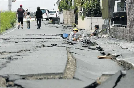  ?? Picture: EPA ?? SHAKEN, NOT SCARED: Children play amid cracks in the road in front of their house after a second powerful earthquake in Japan