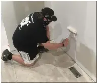  ??  ?? Perry High School freshman Devin Dennison paints the kitchen of a house on Utah Court in Perry Township during a home-renovation class on May 11.