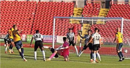  ?? PICTURE: CHARLIE WAUGH ?? ■ Woking defender Luke Wilkinson fires home his side’s third goal