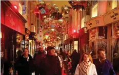  ?? Reuters ?? People walk through the Burlington Arcade shopping walk with Christmas decoration­s in London, Britain, on Sunday.