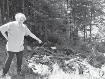  ?? KATIE DEROSA ?? Metchosin resident Tom Adamasak near the bags of garbage dumped on a Sooke Road property that included several people’s private and financial informatio­n.