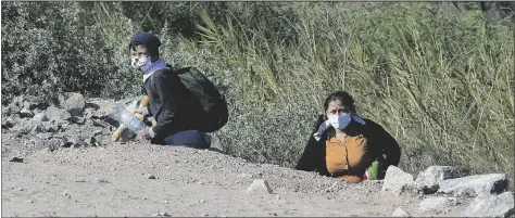  ??  ?? A YOUNG BOY AND WOMAN FROM GUATEMALA ENTER the United States illegally after crossing the Colorado River below Morelos Dam early Tuesday morning near County 8 1/2 Street and the Yuma Levee Road.