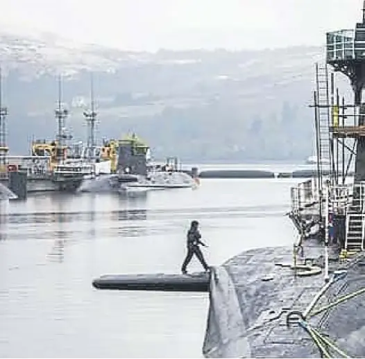  ?? ?? The Vanguard-class submarine HMS Vigilant, one of the UK’S four nuclear warhead-carrying submarines, is pictured at HM Naval Base Clyde. Angus Robertson, right, is confident Scotland can stand up to Vladimir Putin, top, left, without a nuclear deterrent.