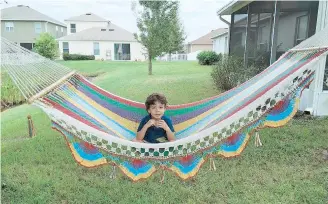  ??  ?? José Carlos, de 4 años, se mece en la hamaca puertorriq­ueña de su casa en Tampa.