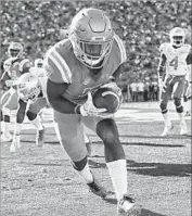  ??  ?? DARREN ANDREWS hauls in a one-yard touchdown pass, capping UCLA’s 17-0 second-half run.