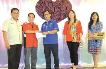  ??  ?? Rolland (centre) presents an MRP cheque to Julau district education officer Thadeus Liam as others look on.