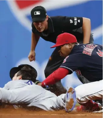  ?? RON SCHWANE/GETTY IMAGES ?? Cleveland’s Jose Ramirez tags out Blue Jay Darwin Barney at second base in the ninth inning.