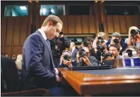  ?? AP PHOTO ?? Facebook CEO Mark Zuckerberg adjusts his tie as he arrives to testify before a joint hearing of the Commerce and Judiciary Committees on Capitol Hill in Washington Tuesday about the use of Facebook data to target American voters in the 2016 election.