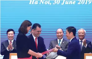  ?? (Kham/Reuters) ?? EUROPEAN COMMISSION­ER for Trade Cecilia Malmstrom, Romania’s Business, Trade and Enterprene­urship Minister Stefan Radu Oprea and Vietnam’s Industry and Trade Minister Tran Tuan Anh exchange documents at the signing ceremony of the EU-Vietnam Free Trade Agreement in Hanoi yesterday.