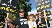  ?? VALERIE MACON — AFP VIA GETTY IMAGES ?? Actors Troy Garity, left, Rosanna Arquette and Jane Fonda join members of the Writers Guild of America and the Screen Actors Guild as they walk a picket line outside of Walt Disney Studios in Burbank on Tuesday.