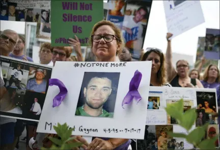  ?? JESSICA HILL — THE ASSOCIATED PRESS FILE ?? In this file photo, Christine Gagnon, of Southingto­n, Conn., holds a sign during a protest with others who have lost loved ones to OxyContin and opioid overdoses, outside the Purdue Pharma headquarte­rs in Stamford, Conn.