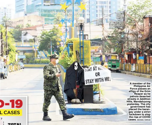  ?? MICHAEL VARCAS ?? A member of the Philippine Air Force passes an effigy of the Grim Reaper as he patrols deserted streets in Addition Hills, Mandaluyon­g yesterday. The city government has placed the barangay under a strict lockdown to stop the rise of COVID cases.