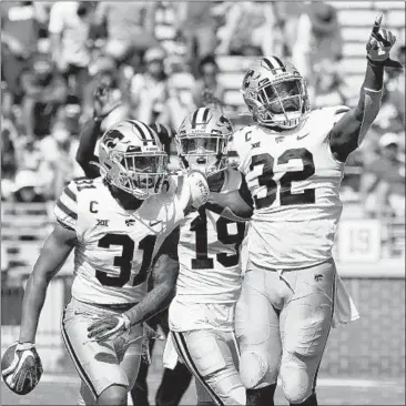  ?? SUE OGROCKI/AP ?? Kansas State’s Jahron McPherson (31) celebrates with teammates after an intercepti­on to seal the win Saturday.