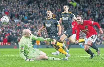  ?? Picture: Shuttersto­ck. ?? Juan Mata lifts the ball past on-rushing Wolves keeper John Ruddy to score Manchester United’s winner at Old Trafford.