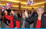  ??  ?? BELFAST: Democratic Unionist Party supporters wave Union flags during the Democratic Unionist Party (DUP) annual conference in Belfast, Northern Ireland. — AFP