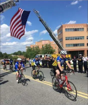  ?? PETE BANNAN – MEDIANEWS GROUP ?? Seventy-five bike riders arrive at Crozer-Chester Medical Center Wednesday as they take part in the National EMS Memorial Bike Ride to honor the lives of EMS providers who have died in the line of service including Crozer’s own Emergency Medical Services Chief Robert ‘Bob’ Reeder, who died in October.