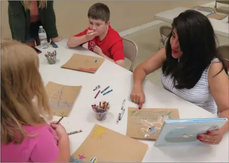  ?? DAVID MEKEEL — MEDIANEWS GROUP ?? Dr. Debora Carrera, state Department of Education executive deputy secretary, does an art project with kids at Boone Area Library. Carrera visited the library to promote a proposal to increase state funding for local libraries.