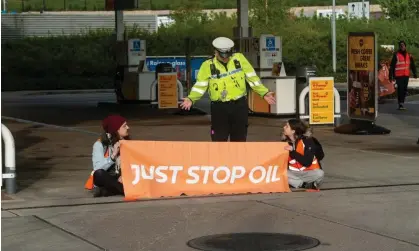  ?? ?? Police arrive on the scene as activists from Just Stop Oil target a Shell petrol station in Cobham. Photograph: Guy Smallman/Getty Images