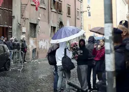  ??  ?? Attesa Un gruppo di studenti appena allontanat­i dalla scuola si ripara dalla pioggia