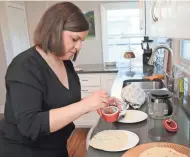  ??  ?? Dorit Hershko drizzles honey onto mufleta pancakes before rolling them up.